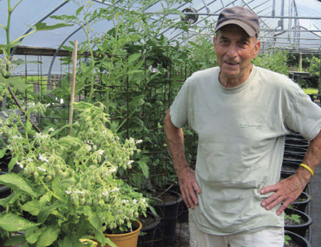 Jack Stacy stands in front of his organic garden