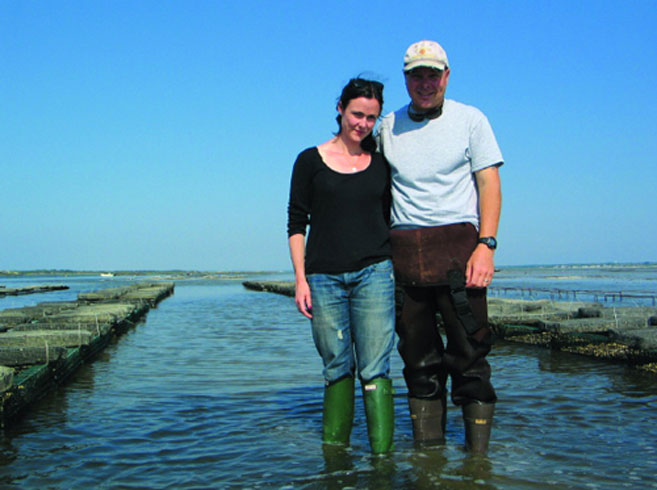 Jon Martin and wife Kate wade in water at Moon Shoal Oysters